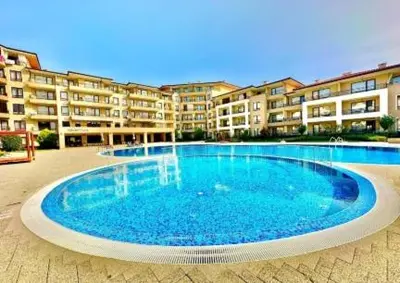 a large blue swimming pool in front of a building at Sveti Vlas Sea Dreams apartament in Sveti Vlas