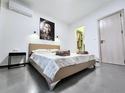 a bedroom with a bed in a white room at Central Park Galleria in Burgas City