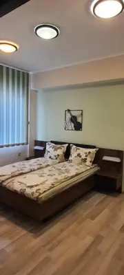 a bed in a bedroom with two lights on the ceiling at Aheloy Apartments in Aheloy