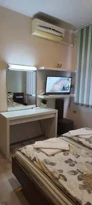 a hotel room with two beds and a flat screen tv at Aheloy Apartments in Aheloy