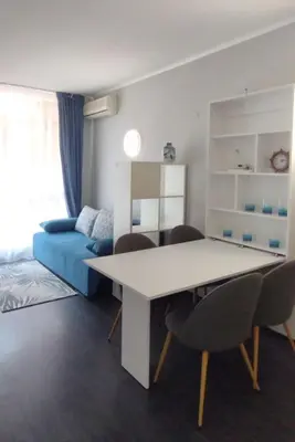 a living room with a table and chairs and a couch at Студия Sunset Beach Солнечный Берег in Sunny Beach