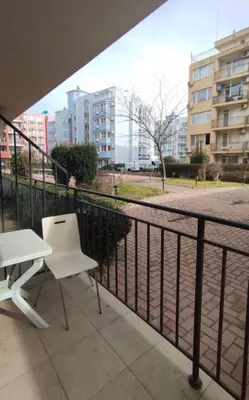 a white chair and a table on a balcony at Студия Sunset Beach Солнечный Берег in Sunny Beach