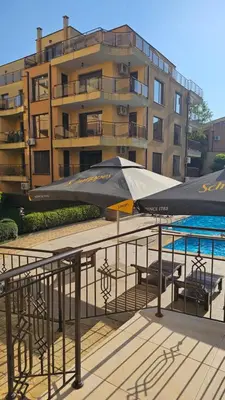 a large umbrella on a balcony next to a building at Three-room apartment in Sveti Vlas