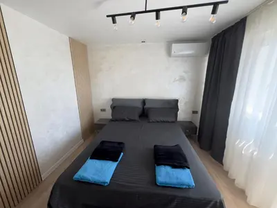 a bedroom with a bed with blue pillows on it at SeaView Lazur Apartment in Burgas City
