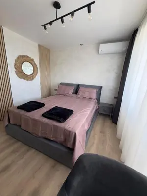 a bedroom with a large bed with pink sheets at SeaView Lazur Apartment in Burgas City