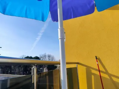 a blue umbrella on top of a yellow building at Apartment SUN RAYS Nesebar in Nesebar