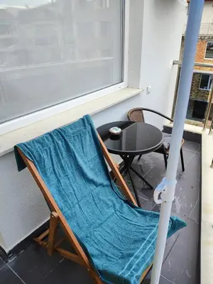 a chair with a blue blanket sitting next to a table at Apartment SUN RAYS Nesebar in Nesebar