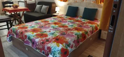 a bedroom with a bed with a colorful comforter at Studio GALILEO in Burgas City