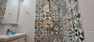 a bathroom with a tiled wall next to a sink at Studio GALILEO in Burgas City