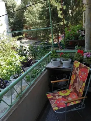 a balcony with a chair and potted plants on it at Римски Терми Варна in Varna City