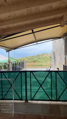 a patio with a table and chairs under awning at Stamopolu Parter in Primorsko