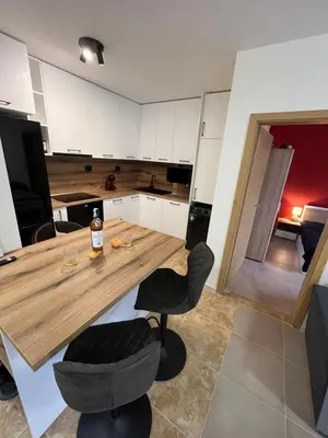 a kitchen with a wooden table and two chairs at River park 2 bedroom apartment in Nesebar