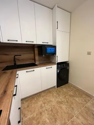 a kitchen with white cabinets and a washing machine at River park 2 bedroom apartment in Nesebar