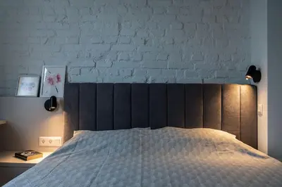 a bedroom with a bed and a white brick wall at Modern & Stylish Sea Apartment with Parking in Burgas City