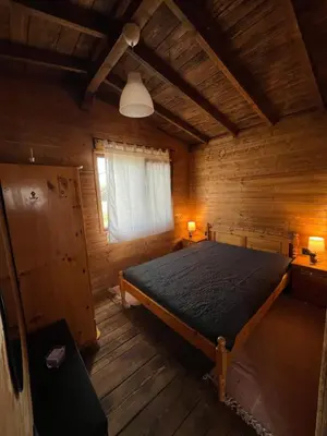 a bedroom with a bed in a wooden cabin at Лятна каравана “Айтата” in Kiten