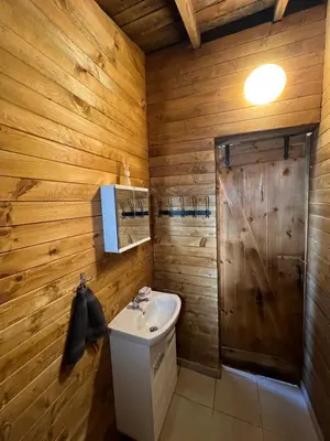 a bathroom with wooden walls and a sink and a shower at Лятна каравана “Айтата” in Kiten