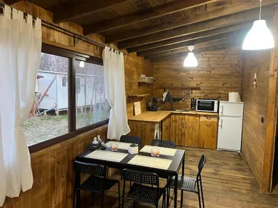 a kitchen with a table and chairs in a cabin at Лятна каравана “Айтата” in Kiten