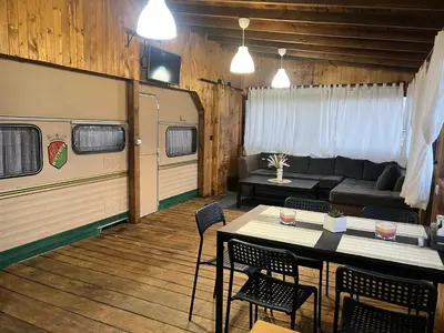 a living room with a couch and a table and chairs at Лятна каравана “Айтата” in Kiten