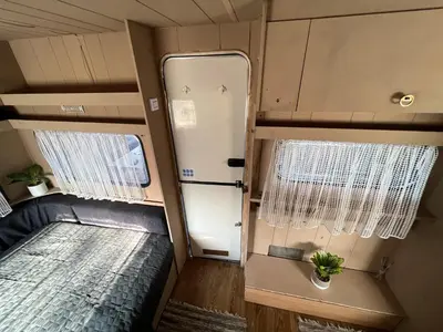 an interior view of an rv with a bed and a door at Лятна каравана “Айтата” in Kiten