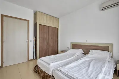 a bedroom with a large bed with white sheets at Апартамент на плаж Градина in Chernomorets