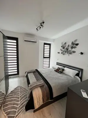 a bedroom with a large bed and two windows at Marino Liberta South Beach Obzor in Obzor