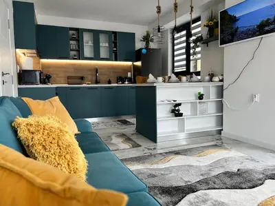 a living room with a blue couch and a kitchen at Marino Liberta South Beach Obzor in Obzor