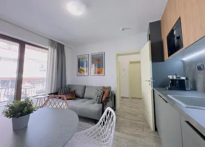 a kitchen and living room with a couch and a table at Valencia Gardens - Private apartment - BSR in Nesebar