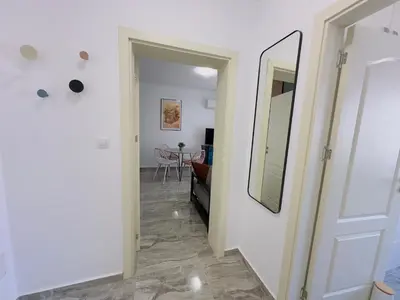 a hallway with a white door and a mirror at Valencia Gardens - Private apartment - BSR in Nesebar
