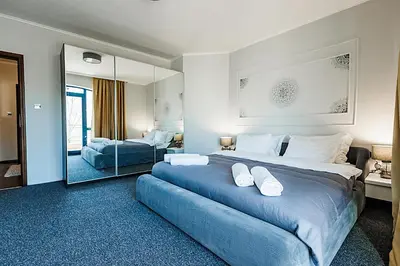 a bedroom with a large blue bed and a mirror at Bella boutique apartment in Sunny Beach