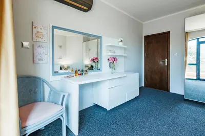 a bathroom with a white vanity with a mirror and a chair at Bella boutique apartment in Sunny Beach