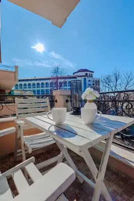 a white picnic table with chairs on a balcony at Bella boutique apartment in Sunny Beach