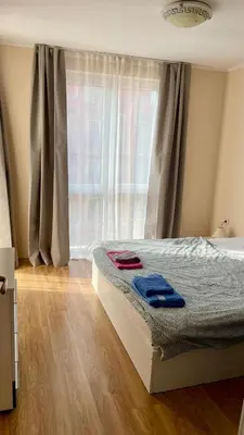 a bedroom with a bed with blue towels on it at 2 Room Apartment in Luxury Complex Sunny Beach in Sunny Beach