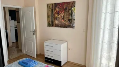 a bedroom with a dresser and a painting on the wall at 2 Room Apartment in Luxury Complex Sunny Beach in Sunny Beach
