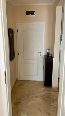 a hallway with a white door and a refrigerator at 2 Room Apartment in Luxury Complex Sunny Beach in Sunny Beach