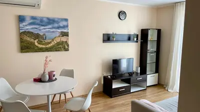 a living room with a white table and a tv at 2 Room Apartment in Luxury Complex Sunny Beach in Sunny Beach