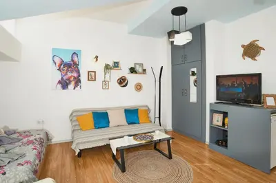 a living room with a couch and a tv at Batak Studio in Burgas City