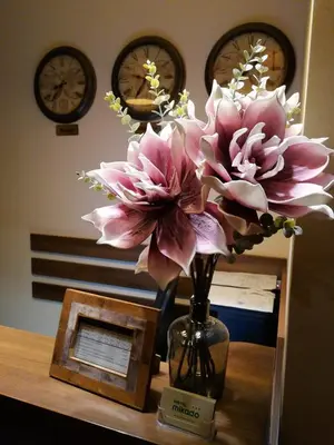 a vase filled with pink flowers on a table at Хотел МИКАДО - онлайн self check-in in Burgas City