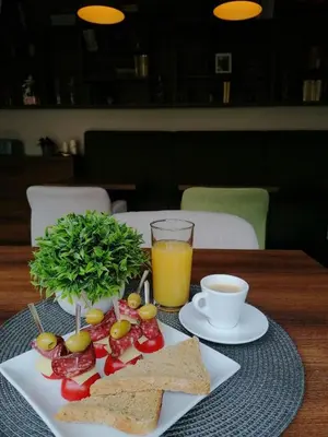 a plate of food with toast and a glass of orange juice at Хотел МИКАДО - онлайн self check-in in Burgas City
