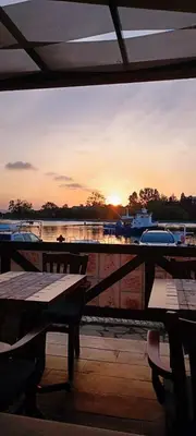 a view of the sunset from a restaurant with tables at Модерен апартамент в сърцето на Созопол in Sozopol
