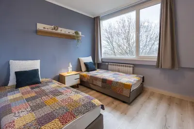 a bedroom with two beds and a window at Happy Lazur in Burgas City