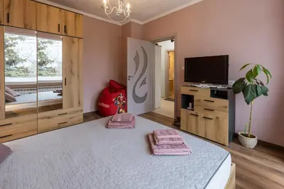 a bedroom with a large bed with pink towels on it at Happy Lazur in Burgas City