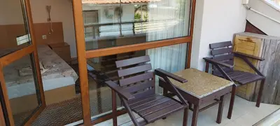 a balcony with a chair and a table and a bedroom at Anchors Guest House in Sozopol