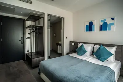 a bedroom with a large bed with blue pillows at Bizarre Boutique Hotel in Varna City