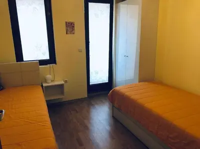 a bedroom with two beds and two windows at Сънрайз Данаилов in Obzor