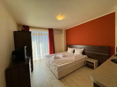 a hotel room with a bed and a television at AFRODITA II - 19 Studio Sunny Beach in Sunny Beach