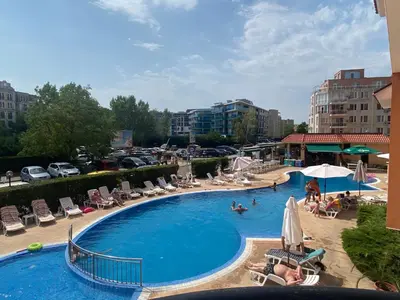 a swimming pool with chairs and people in a resort at KASANDRA 'Д' 5 Apartment Sunny Beach in Sunny Beach