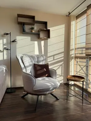 a living room with a white chair and a table at Home by the Sea in Burgas City