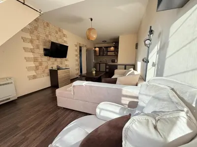a living room with a couch and a tv at Home by the Sea in Burgas City