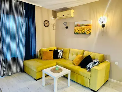 a living room with a yellow couch and a table at Blue Marine - Daneli Apartment in Sunny Beach