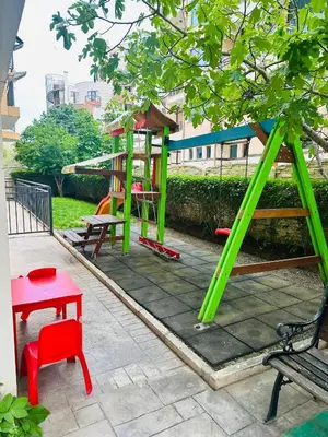 a playground with green and red chairs and a bench at Blue Marine - Daneli Apartment in Sunny Beach